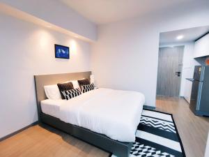 - une chambre avec un grand lit blanc et des oreillers dans l'établissement Star Sukhumvit, à Bangkok