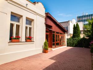 a white building with windows and potted plants at Pribina Penzión in Nitra