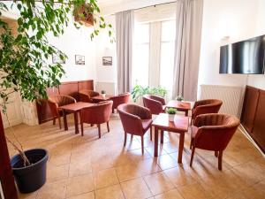 a waiting room with tables and chairs and a plant at Pribina Penzión in Nitra