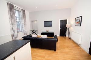 sala de estar con sofá negro y TV en Parkhill Luxury Serviced Apartments - City Centre Apartments, en Aberdeen