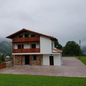 Casa blanca grande con balcón en la parte superior en Posada las Albarcas, en La Cavada