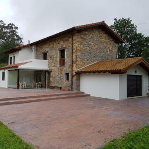 una casa con un gran patio frente a ella en Posada las Albarcas, en La Cavada