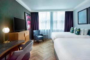 um quarto de hotel com duas camas e uma televisão de ecrã plano em NYX Hotel London Holborn by Leonardo Hotels em Londres