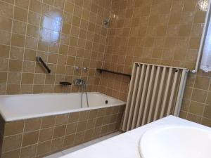 a bathroom with a tub and a toilet and a sink at Haus Gizella in Harkány