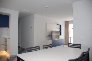 a kitchen with a table and chairs in a room at Apartamentos Sunway Arizona in Sitges