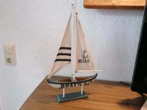 een kleine houten speelgoedzeilboot op een houten vloer bij Boddenhus auf Rügen - Ferienwohnungen und Pension in Rappin