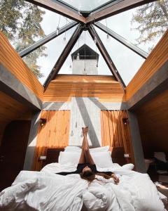 a person laying on a bed in a room with windows at Stara Pravda Villas in Bukovel