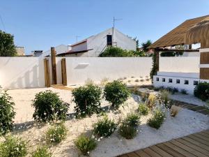 einen Garten mit Pflanzen vor einem Zaun in der Unterkunft Cabana 2 da Comporta in Comporta