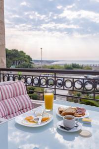 einem Tisch mit zwei Teller Essen und einem Glas Orangensaft in der Unterkunft Adriatic Apartment in Ulcinj