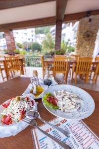 einem Holztisch mit zwei Teller Essen drauf in der Unterkunft Adriatic Apartment in Ulcinj