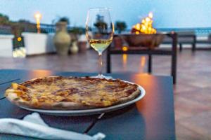 eine Pizza auf dem Tisch mit einem Glas Wein in der Unterkunft Adriatic Apartment in Ulcinj