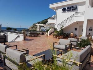 eine Terrasse mit Stühlen und Tischen auf einem Gebäude in der Unterkunft Adriatic Apartment in Ulcinj