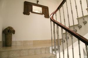 una escalera con espejo y un jarrón de flores en Hotel Restaurante Rúas, en Pontevedra