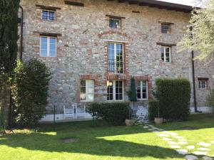 ein Steinhaus mit zwei weißen Stühlen im Hof in der Unterkunft Apartment Monika in Udine