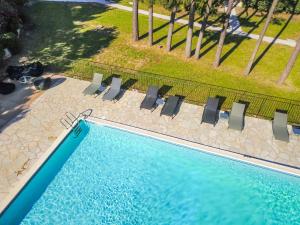 - une vue sur la piscine et ses chaises dans l'établissement Prea Gianca, à Bonifacio