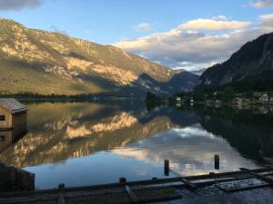 uma vista para um lago com montanhas ao fundo em Landhaus Hallstättersee em Bad Goisern