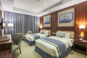 een hotelkamer met 2 bedden en een bureau bij Seasons Park- mawasim al hay at hotel in Jeddah