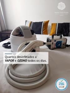 una aspiradora en una cama con una máquina en ella en Rainha Santa Isabel - Óbidos History Hotel, en Óbidos