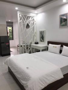 um quarto com uma grande cama branca e uma secretária em Cosy Star Apartment and Motel em Hai Phong