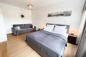 een slaapkamer met een bed en een bank bij Luxus-Apartment in Leipzig mit Privat-Parkplatz in Leipzig