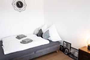 een slaapkamer met een bed met witte lakens en kussens bij Luxus-Apartment in Leipzig mit Privat-Parkplatz in Leipzig