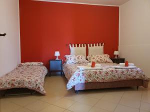 1 Schlafzimmer mit 2 Betten und einer roten Wand in der Unterkunft B&B Odeon in Taormina