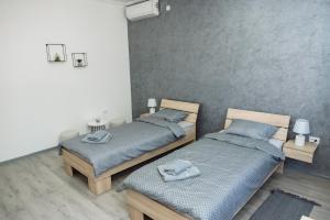 2 camas individuales en una habitación con 2 mesas en D&D apartments, en Subotica