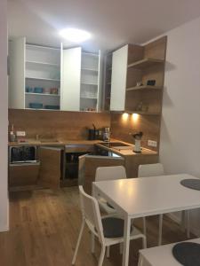 a kitchen with white cabinets and a table and chairs at Apartmán Jeleň Chopok Juh-Trangoška in Tale