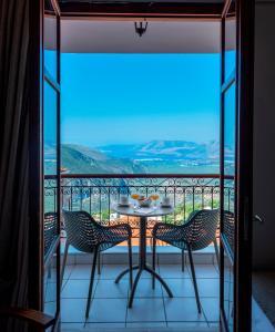 una mesa y sillas en un balcón con vistas en Fedriades Delphi Hotel, en Delfos