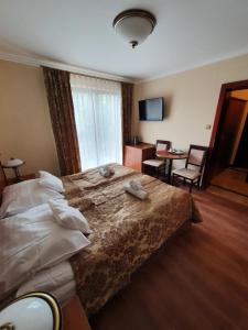 Habitación de hotel con cama, mesa y sillas en Villa Meridian, en Trzęsacz