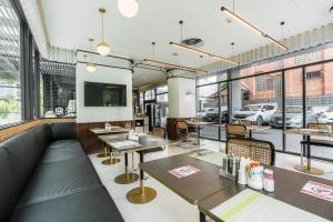 un restaurant avec des tables, des chaises et des fenêtres dans l'établissement Hotel Amber Sukhumvit 85, à Bangkok