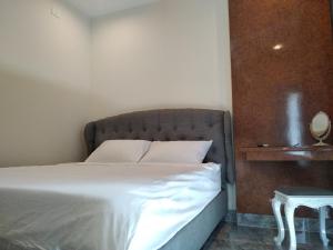 Un dormitorio con una cama grande con sábanas blancas y una mesa. en PEACE HOTEL, en Vung Tau