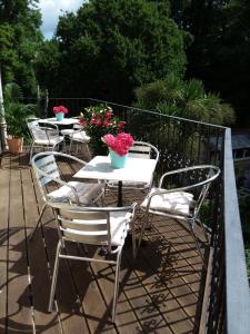 een rij tafels en stoelen op een balkon met bloemen bij Chine Side in Shanklin