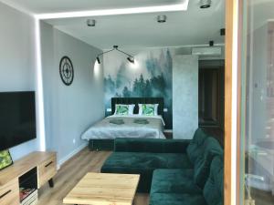 ein Wohnzimmer mit einem Sofa und einem Bett in der Unterkunft Marina Green Loft-Apartament przy promenadzie in Lyck