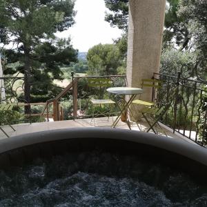 bañera de hidromasaje en un patio con mesa en Le Mas des Roches à Velaux, en Velaux