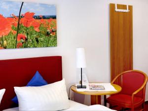 a room with a bed and a table and a chair at centra Hotel in Schwedt