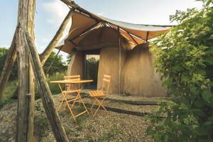 einen Tisch und zwei Stühle vor einem Zelt in der Unterkunft Terragora Lodges - Hébergement atypique in Les Épesses