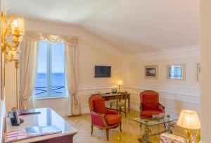 een woonkamer met een tafel en stoelen en een raam bij Grand Hotel Excelsior Vittoria in Sorrento