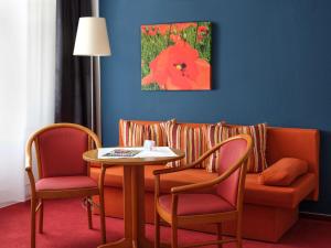 a living room with a couch and a table and chairs at centra Hotel in Schwedt