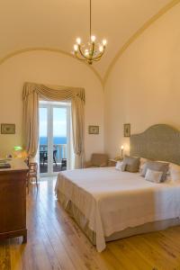 een slaapkamer met een bed, een bureau en een raam bij Grand Hotel Excelsior Vittoria in Sorrento