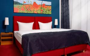 a red bed with a red headboard in a bedroom at centra Hotel in Schwedt