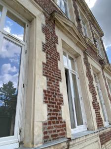 un vecchio edificio in mattoni con due finestre sopra di Trankil-Apparts Centre 2 a Saint-Quentin