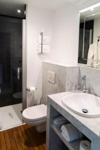 a bathroom with a sink and a toilet and a shower at Hôtel Merveilleux Côté Mer in Dunkerque