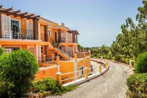 une maison orange avec une route devant elle dans l'établissement Colina da Lapa & Villas, à Carvoeiro