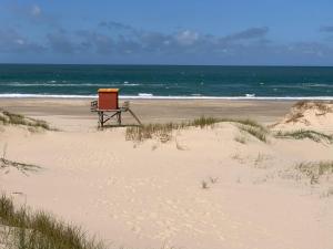 eine Bank am Strand in der Nähe des Ozeans in der Unterkunft Complejo Casas del Mirador in Barra del Chuy