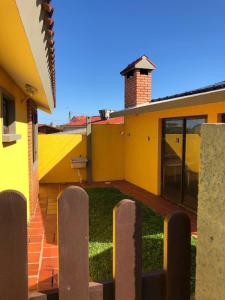 ein gelbes Haus mit einem gemauerten Kamin darüber in der Unterkunft Complejo Casas del Mirador in Barra del Chuy