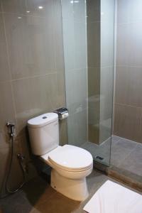 uma casa de banho com um WC e uma cabina de duche em vidro. em Winstar Hotel em Pekanbaru