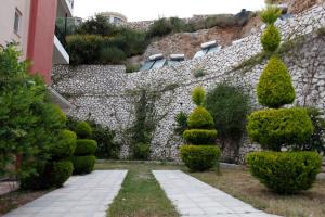 un giardino con alberi e un muro di pietra di Katerina Lefkada a Vassiliki