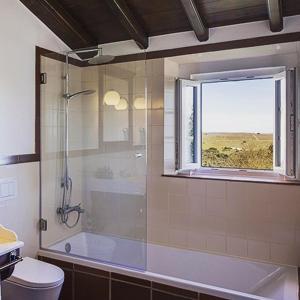 a bathroom with a shower and a toilet and a window at Hotel Rural Monte da Provença in Elvas