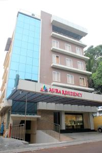 um grande edifício cor-de-rosa com um cartaz. em Aura Residency em Thrissur